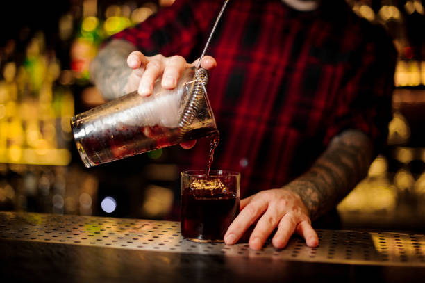 istock Bartender pouring a Hamm's Delight cocktail from the measuring cup with spoon 1073166732
