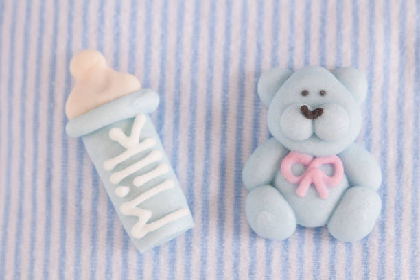 Baby Boy Background striped baby shirt in soft pastel blue with milk bottle and teddy bear made of icing sugar, perfect for baby shower party, Invitation, baptism, birth, birthday, everything around babies and pregnancy showers of blessings stock pictures, royalty-free photos & images
