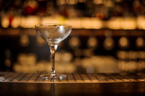 istock Empty cocktail glass standing on the steel bar counter 1073168062