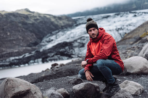 istock man sitting on a glacier in iceland 1073176724