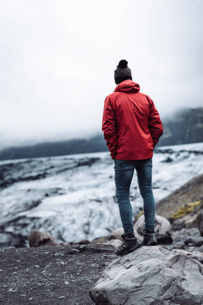 istock man sitting on a glacier in iceland 1073177340