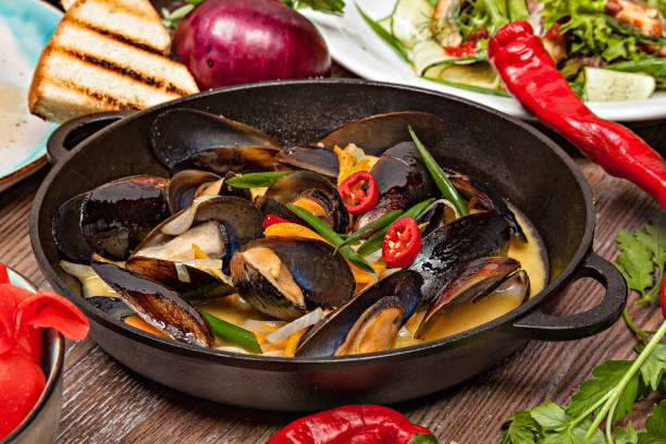 istock Delicious seafood mussels with sauce in a pan. 1073185004