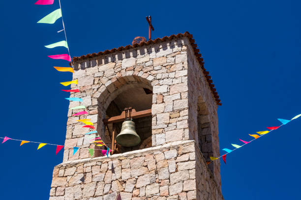 Clocher et Bell, drapeaux colorés et ciel bleu, l’église de Saint Antoine de Padoue à Baia Sardinia, & ciel bleu. Baia Sardinia, Gallura, Sardaigne, Italie. - Photo