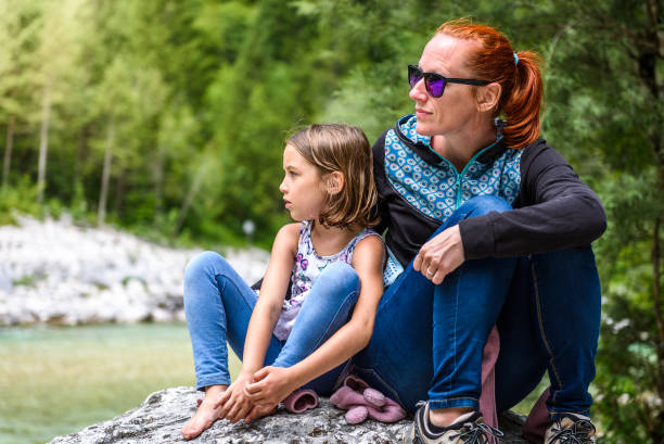 istock Family sitting on river rock after nature hiking. 1073189596