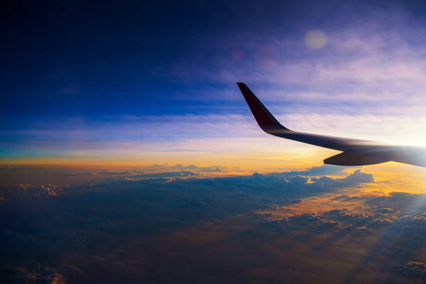 istock Sunrise sky with wing from window of airplane 1073191024