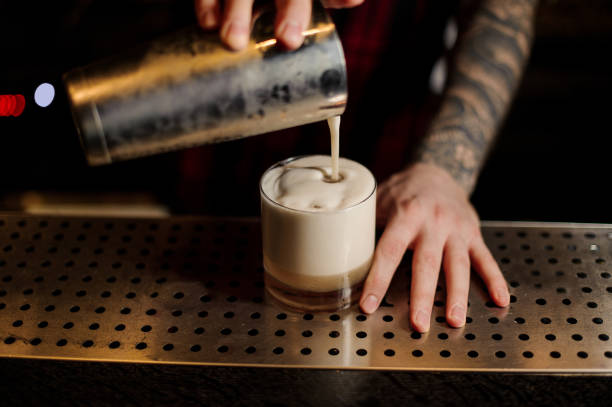 istock Bartender pouring fresh thick creamy alcoholic drink into a glass 1073195046