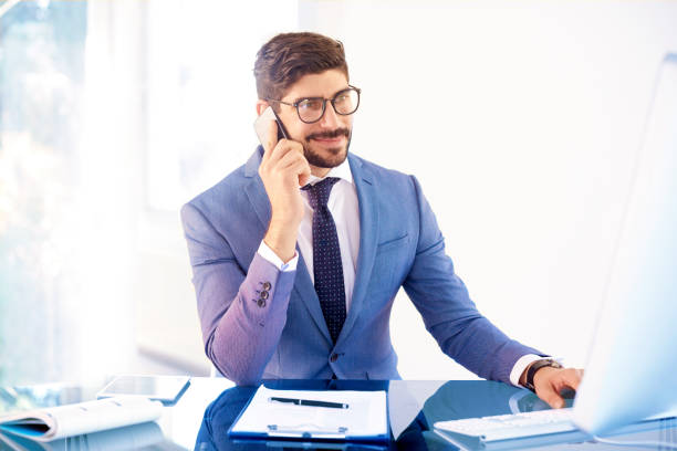 istock Handsome young professional man making business call in the office 1073198744