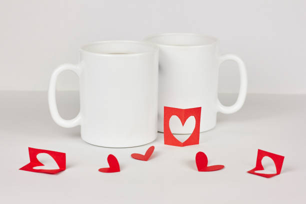istock Red paper hearts and two cups on white background 1073201010