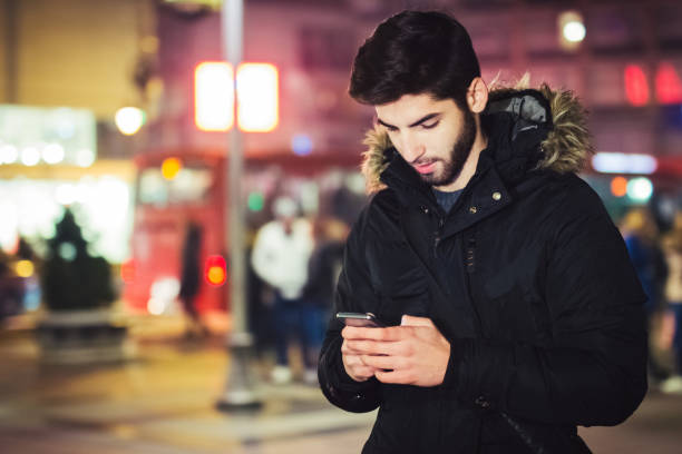 istock young man in  city looking at smart phone and typing 1073203318