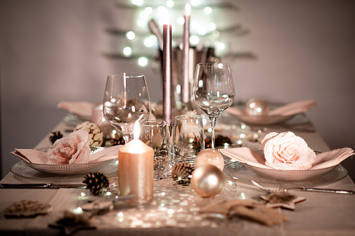 christmas eve party table with wine glass and glitter season's greeting decoration