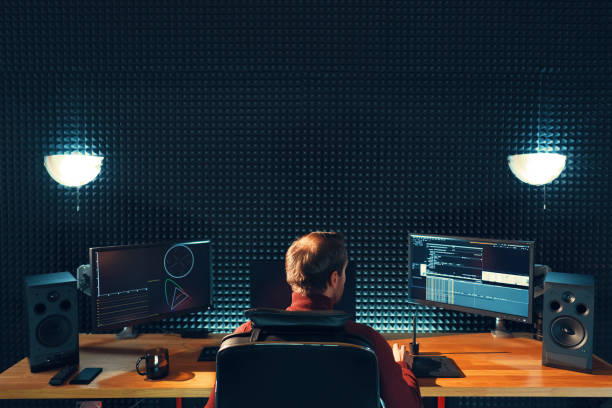 istock Back view of young man watching graphs on monitors 1073209536