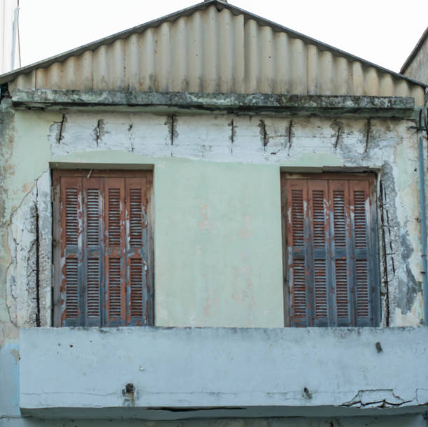 istock Old damaged wall with barred  two windows 1073212764
