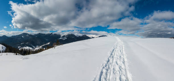 istock Sledge trace and footprints on winter mountain hill top 1073213564