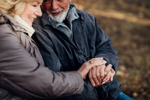 istock Senior couple holding hands in a park 1073216264