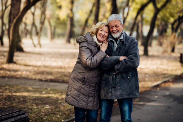 istock Smiling romantic senior couple walking in a park 1073216418