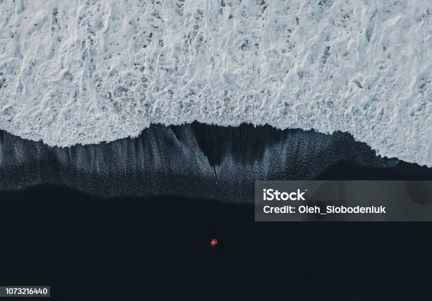 Aerial View Of Woman On Black Sand Beach In Iceland Stock Photo - Download Image Now