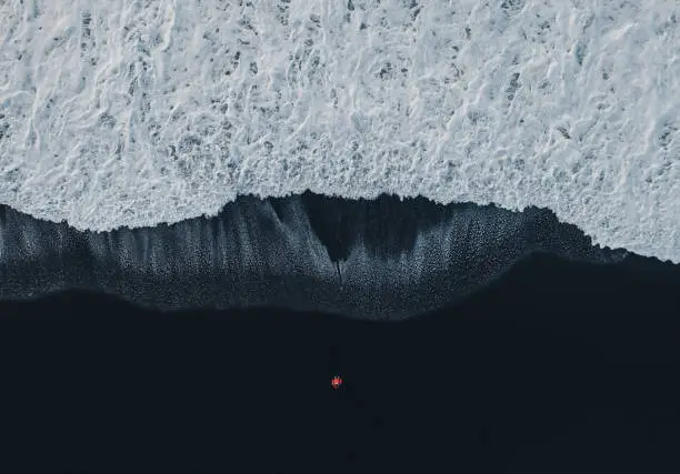 Photo of Aerial view of woman on black sand beach in Iceland