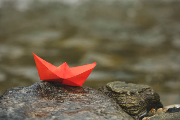 istock Paper boat on the rock 1073217062