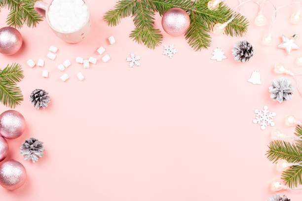 istock Christmas background with fir branches, lights, purple giftboxes, pink decorations, hot drink with marshmallows on pink 1073225872