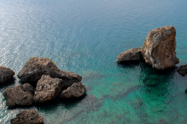 istock rock formations on coast of see, Crystal clear water, Top view 1073228882