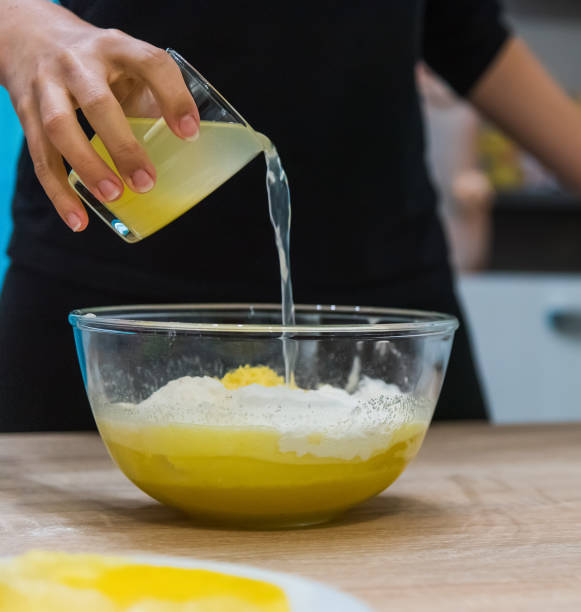 istock Woman pouring lemon juice in a cake dough 1073229720