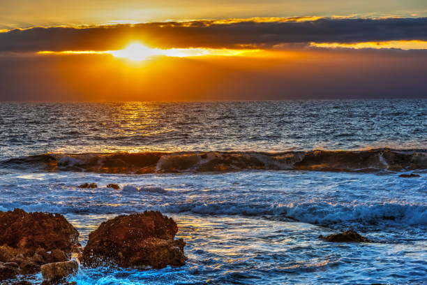 istock Rocks and rough sea at sunset 1073231220