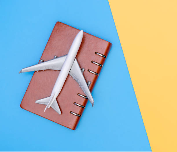 istock white toy plane on blue and yellow background 1073234058