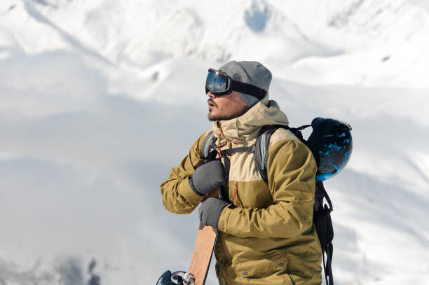 istock Man standing with the snowboard on the snowy mountains 1073234952