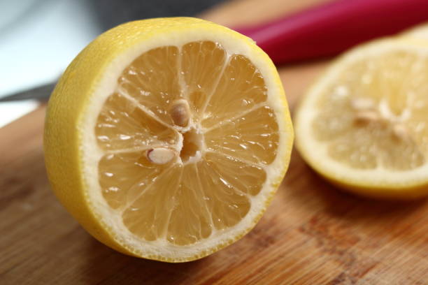 istock Cross section of lemon on wooden cutting board 1073238108