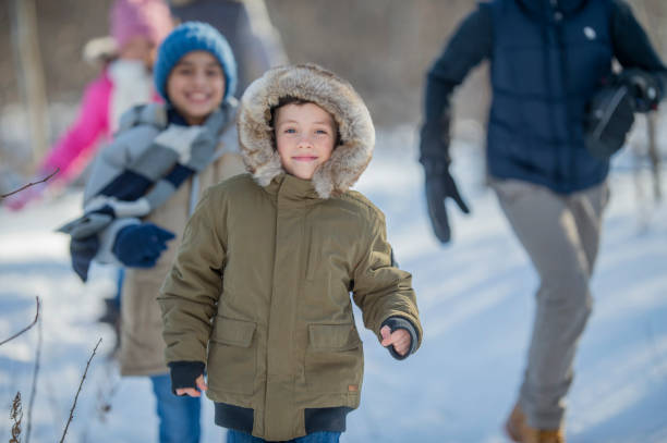istock Little boy running through the snow 1073242158