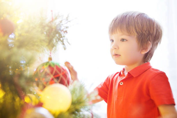istock Little boy decorating Christmas tree with toy balls 1073250196