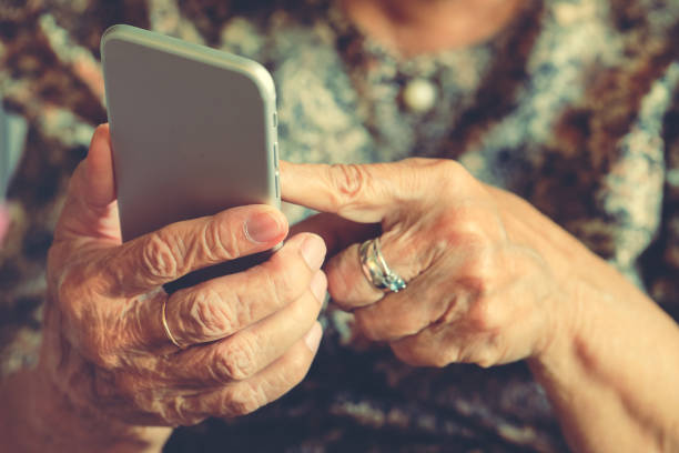 istock Elderly woman holding a mobile phone 1073251010