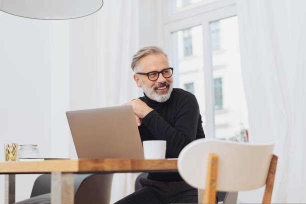 улыбающийся бизнесмен смотрит в сторону - computer old men laptop стоков�ые фото и изображения
