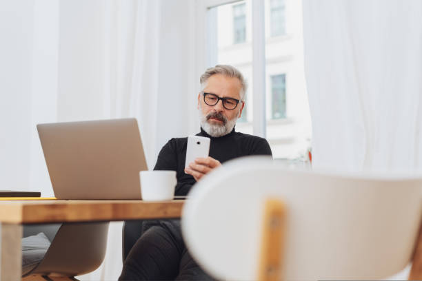 istock Businessman reading a message on his mobile 1073253586