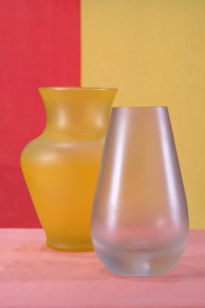 istock Still life with yellow and pink vases placed on the table on a multicolored background 1073255732