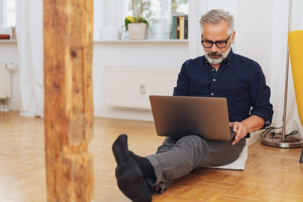 istock Man working on laptop while sitting on the floor 1073256118