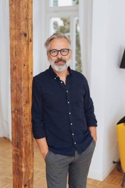 istock Senior man leaning against a wooden post 1073257608