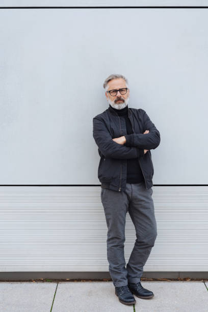istock nonchalant man standing leaning against a wall 1073257666