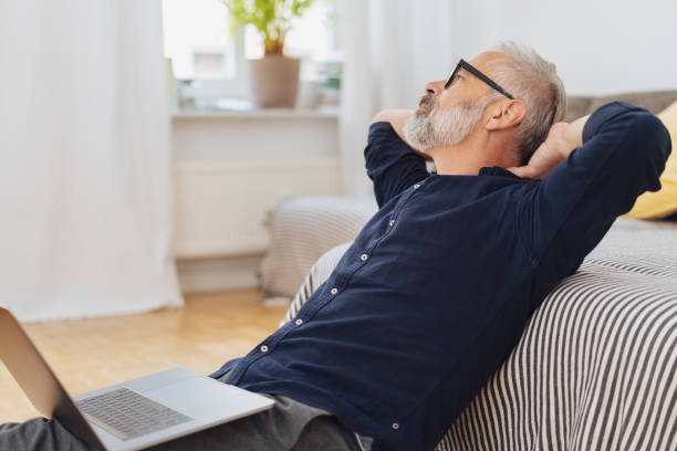 istock Middle-aged man relaxing on a sofa at home 1073258878