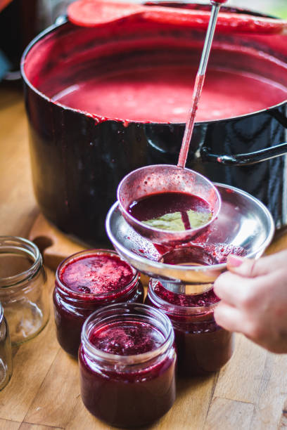 dokonywanie cherry jam - pouring liquid syrup red zdjęcia i obrazy z banku zdjęć