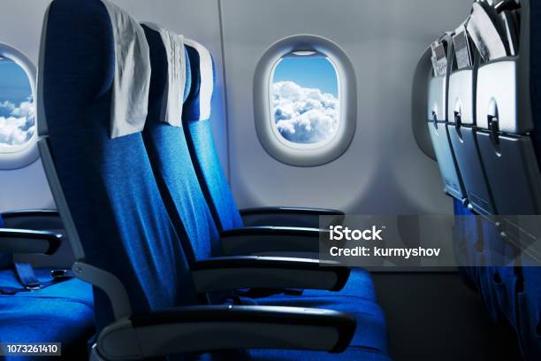 Empty Air Plane Seats Blue Sky And Clouds In The Window Airplane Interior Stock Photo - Download Image Now