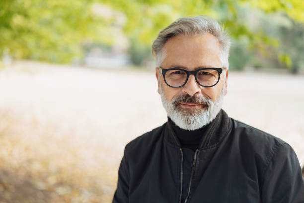 istock Pensive older bearded man outdoors in a park 1073261488