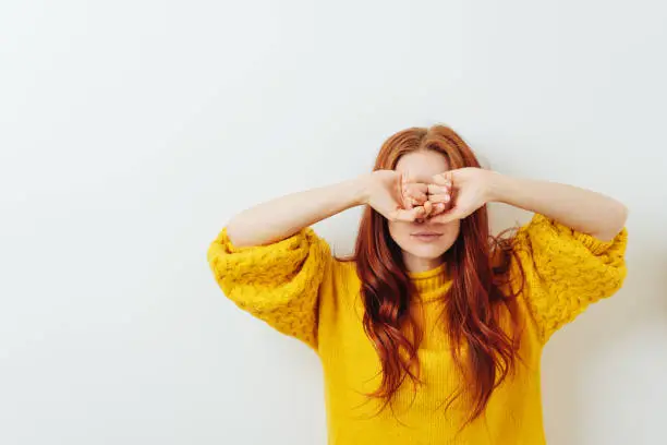 Photo of woman hiding her face with both hands