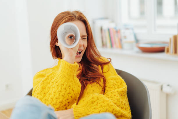 redhead woman looking through paper telescope - non moving activity imagens e fotografias de stock