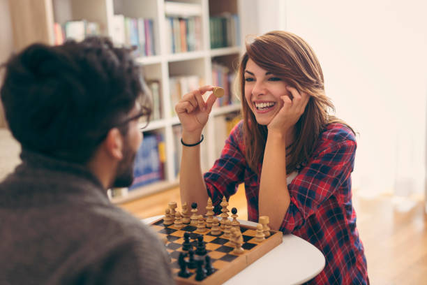 pareja jugando al ajedrez - juego de ajedrez fotografías e imágenes de stock