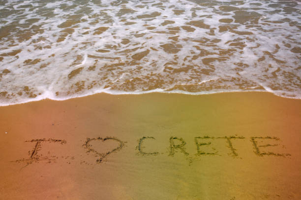 istock Love Crete words on sand beach texture with sea wave on background. Summer concept 1073280746