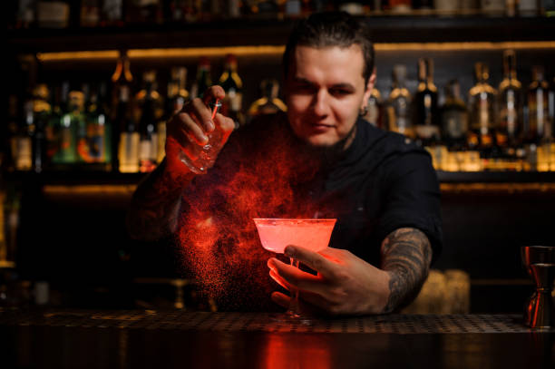 istock Bartender sprinkling red colored bitter into a cocktail glass 1073297204