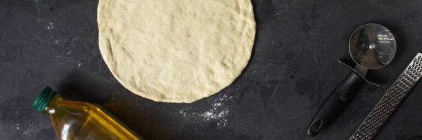 istock pizza - dough, preparation, flat cake (the process of cooking). Top view with copy space 1073300056
