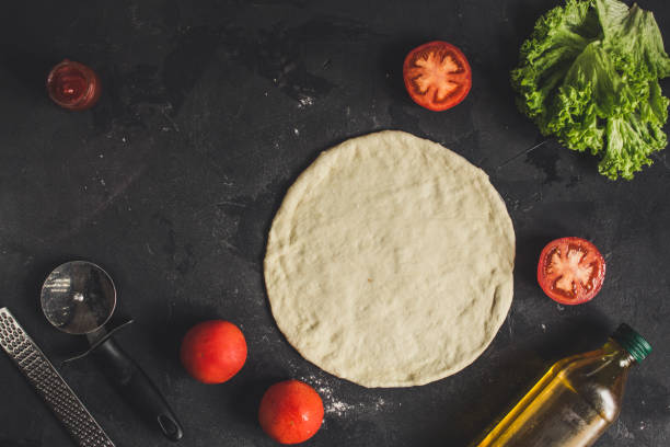 istock pizza - dough, preparation, flat cake (the process of cooking). Top view with copy space 1073300060
