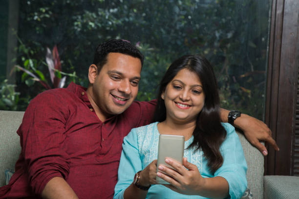 istock Indian Couple Using Phone - Stock images 1073303918